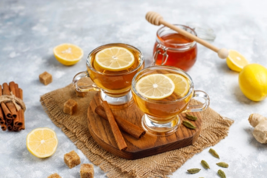 A cup of tea,brown sugar,honey and lemon on concrete  background